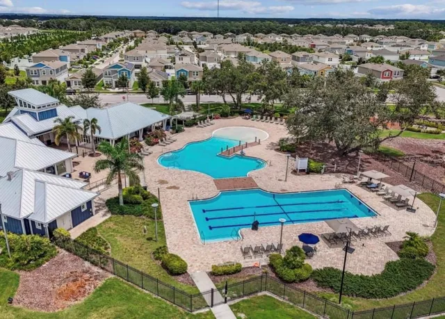 an aerial view of residential houses with outdoor space and swimming pool