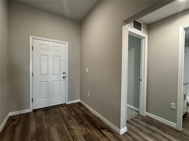 a view of a hallway with wooden floor and entryway