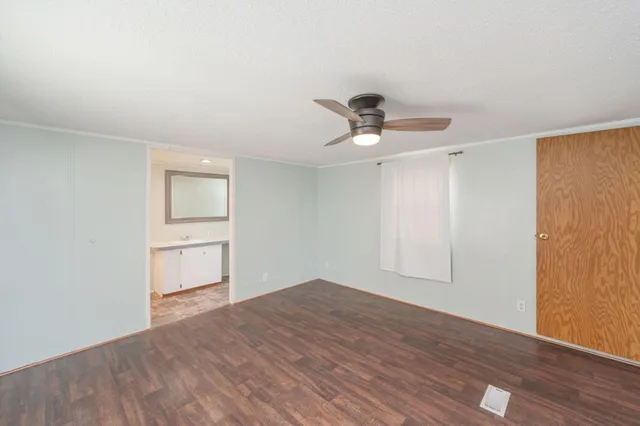 a view of empty room with wooden floor