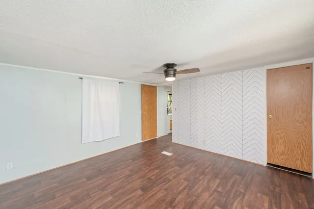 a view of an empty room with wooden floor