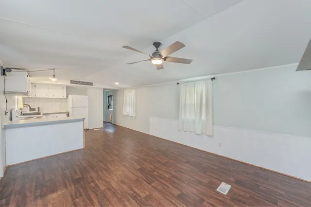 a view of an empty room and window and wooden floor