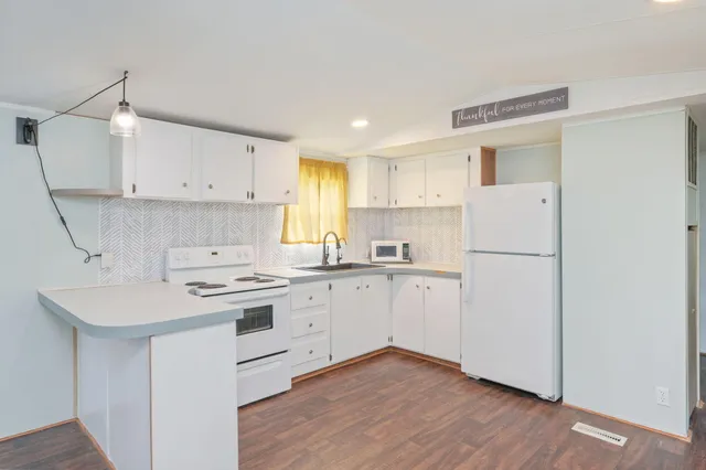 a kitchen with white cabinets and white appliances