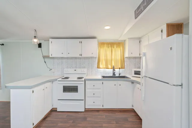 a kitchen with white cabinets and white appliances