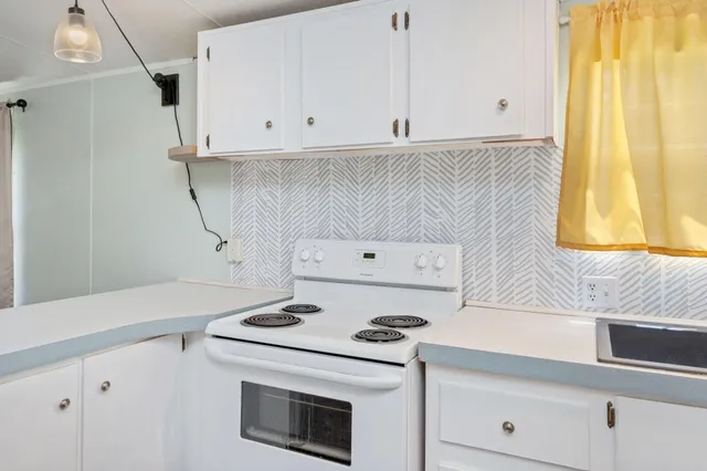 a kitchen with a stove and white cabinets