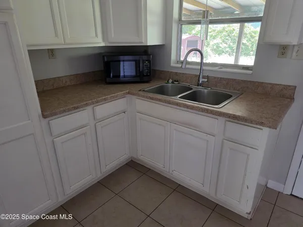 a kitchen with granite countertop white cabinets and sink