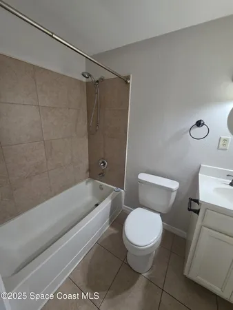 a white toilet and tub sitting next to a bathroom sink