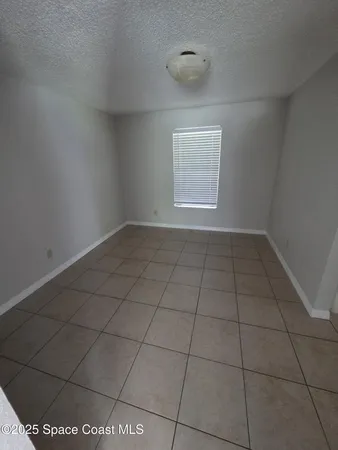 an empty room with a white cabinet and a window