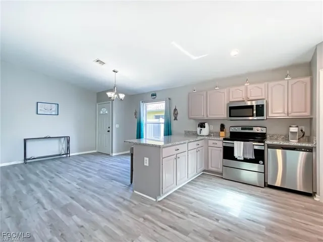 a kitchen with granite countertop a stove top oven and cabinets