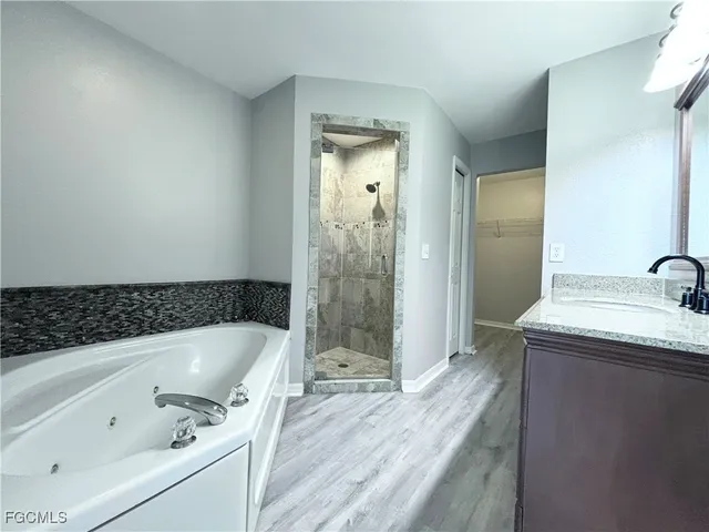 a bathroom with a granite countertop tub sink and shower