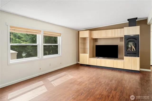 a view of a living room with wooden floor and a fireplace