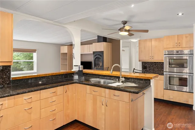 a kitchen with granite countertop a refrigerator sink and microwave