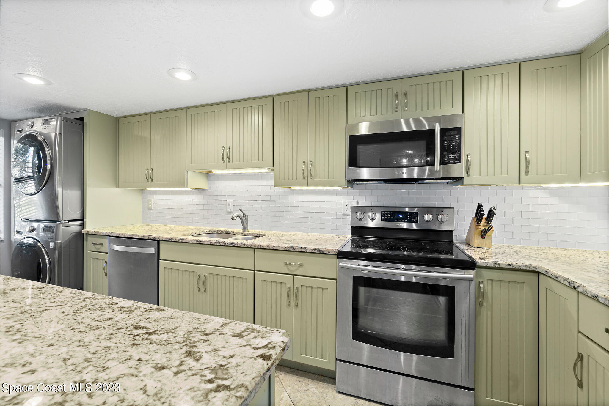 500 Catalina Road, Unit 103 Cocoa Beach, FL 32931 - Photo 3 of 28 a kitchen with a sink stove and microwave