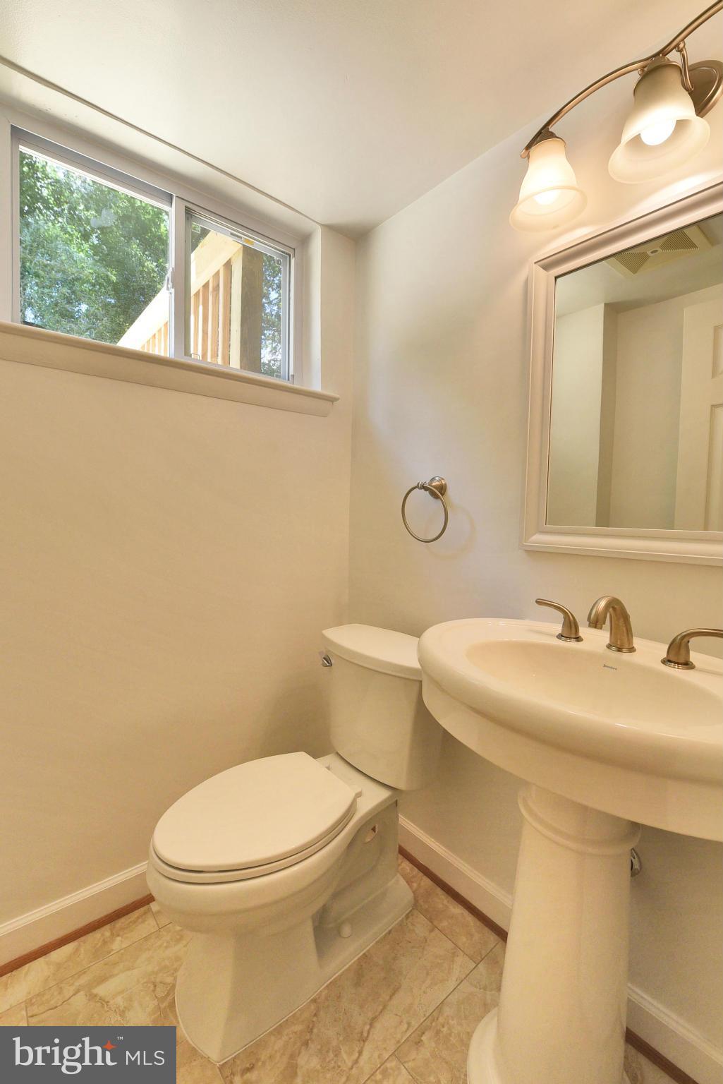 13516 Collingwood Terrace Silver Spring, MD 20904 - Photo 19 of 29 a bathroom with a toilet a sink a mirror and a window