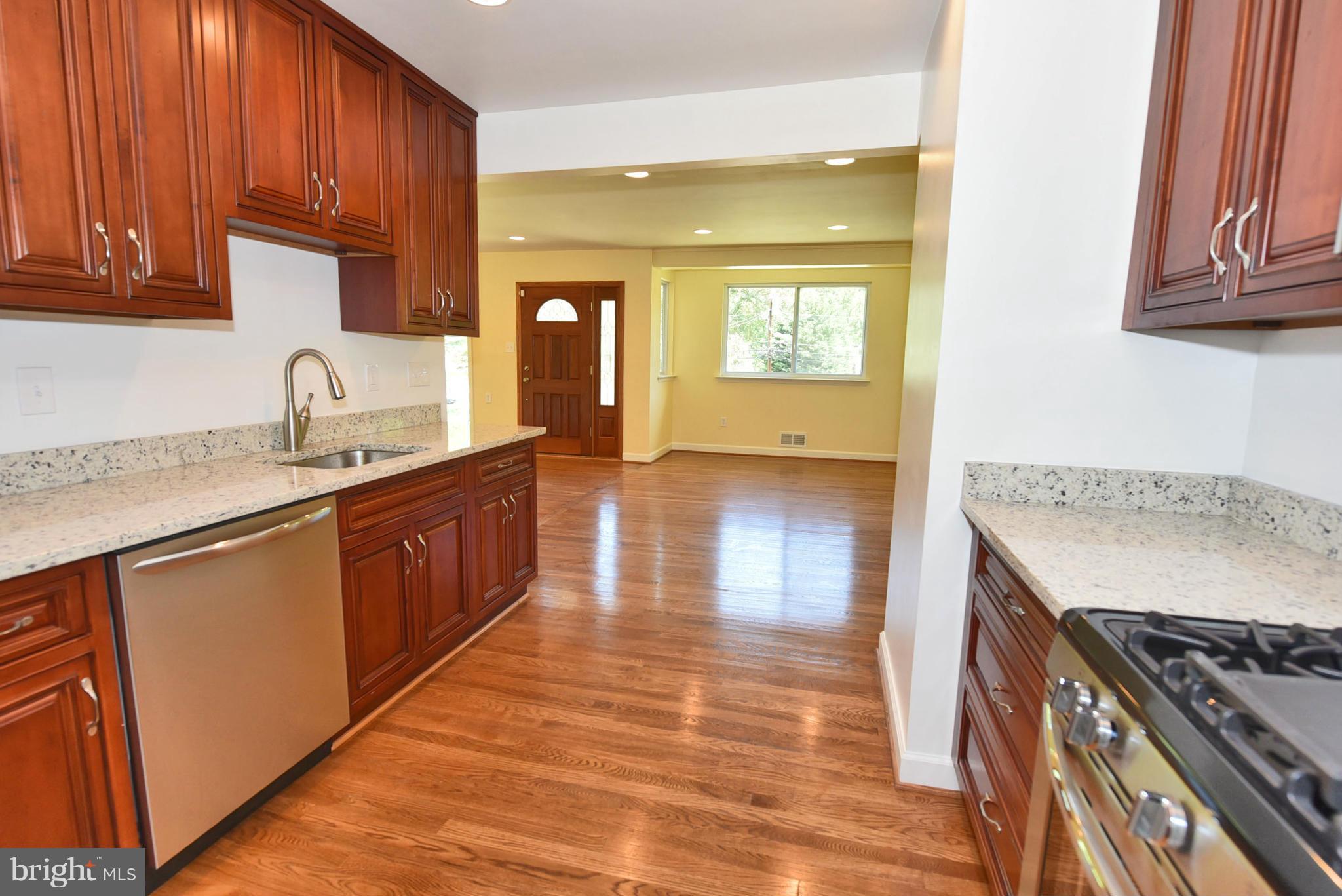 13516 Collingwood Terrace Silver Spring, MD 20904 - Photo 8 of 29 a kitchen with granite countertop a sink a stove cabinets and wooden floor
