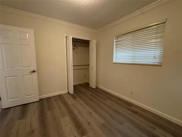 an empty room with wooden floor and closet
