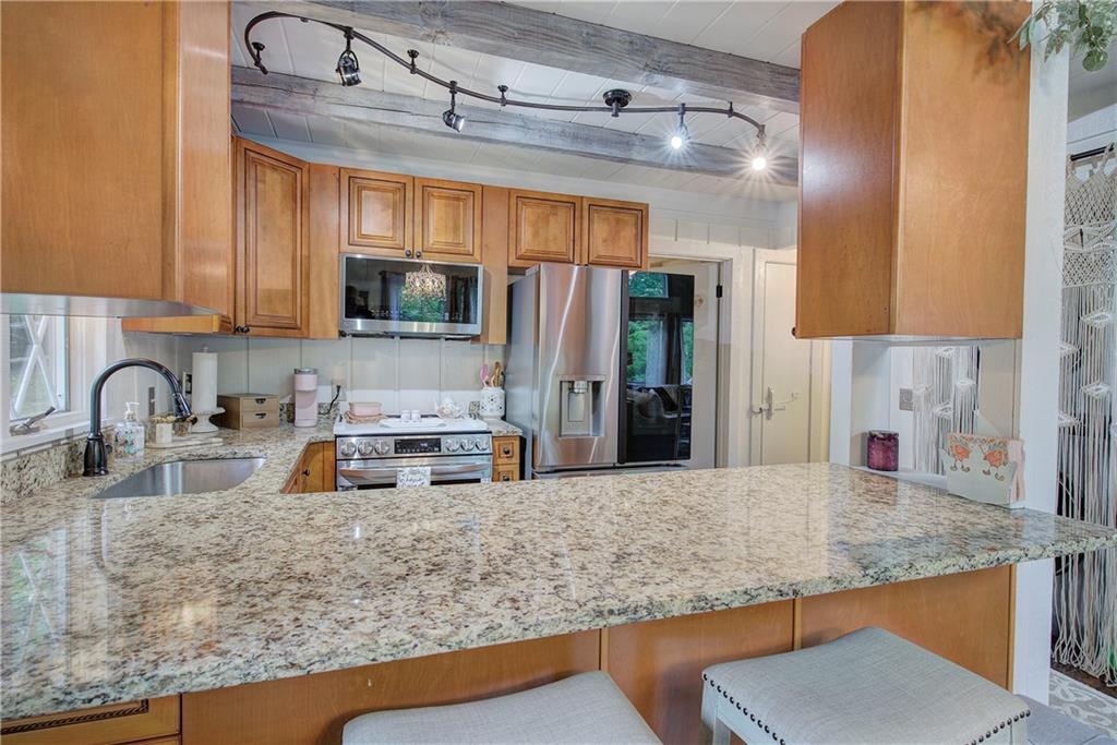 298 Lake View Trace Jasper, GA 30143 - Photo 15 of 33 a kitchen with stainless steel appliances granite countertop a sink a stove and a refrigerator with wooden floor