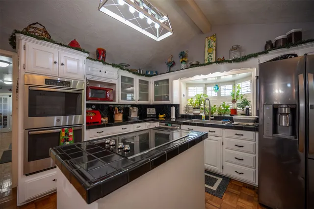 a kitchen with stainless steel appliances granite countertop a sink and cabinets