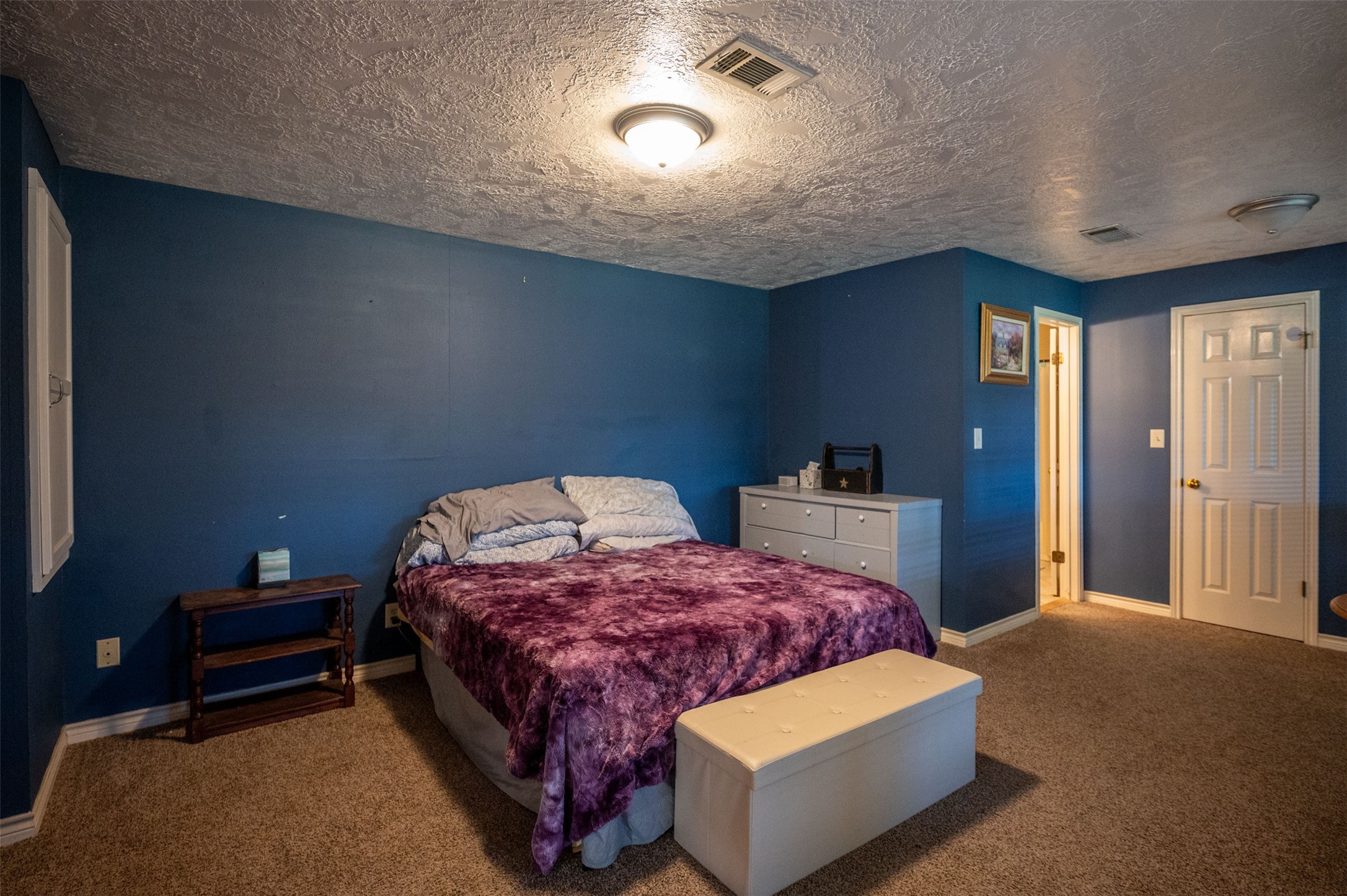228 Camden Road Chester, TX 75936 - Photo 36 of 50 a bedroom with a bed and a lamp with the wooden floor