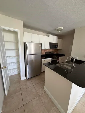 a kitchen with a sink a refrigerator and washer