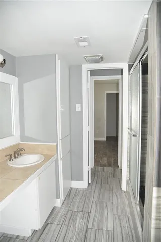 a view of an empty room with wooden floor and closet