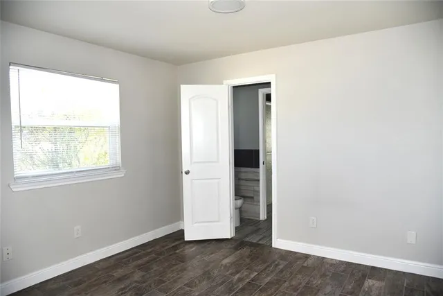 an empty room with wooden floor and a window