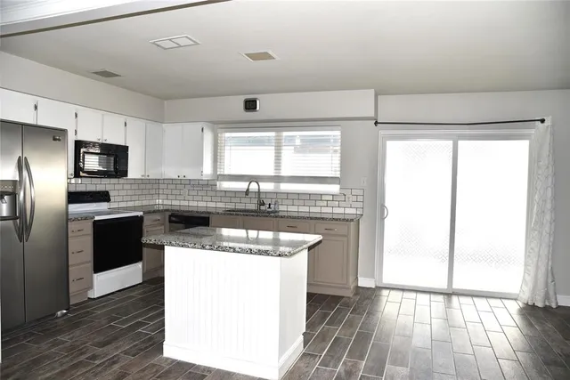 a kitchen with a stove a sink and a refrigerator