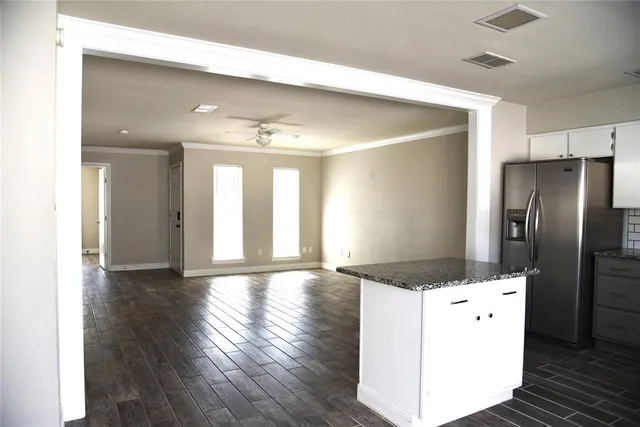 a view of a refrigerator in kitchen and wooden floor