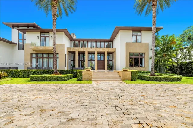 a front view of a house with a yard and potted plants