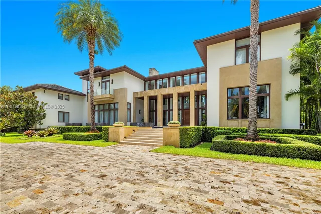 a front view of a house with a yard and potted plants