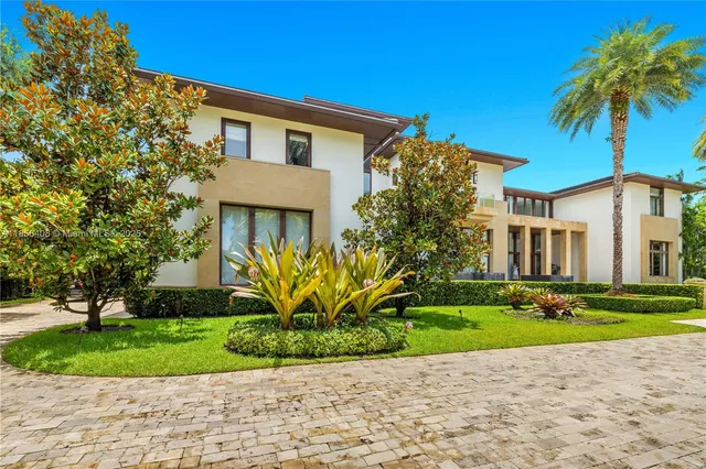 a front view of a house with a yard and potted plants