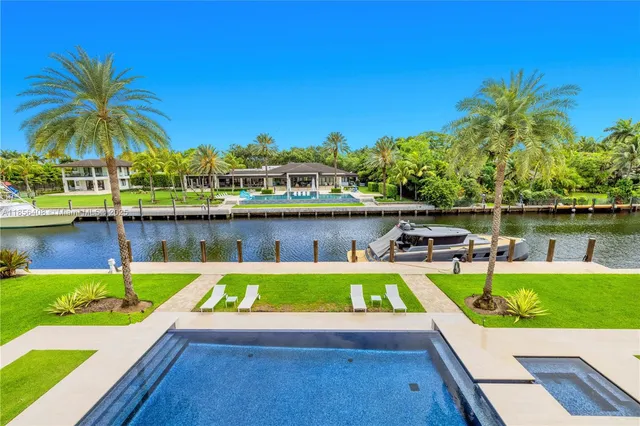 an aerial view of residential houses with outdoor space and lake view