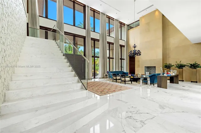 a living room with furniture and floor to ceiling windows
