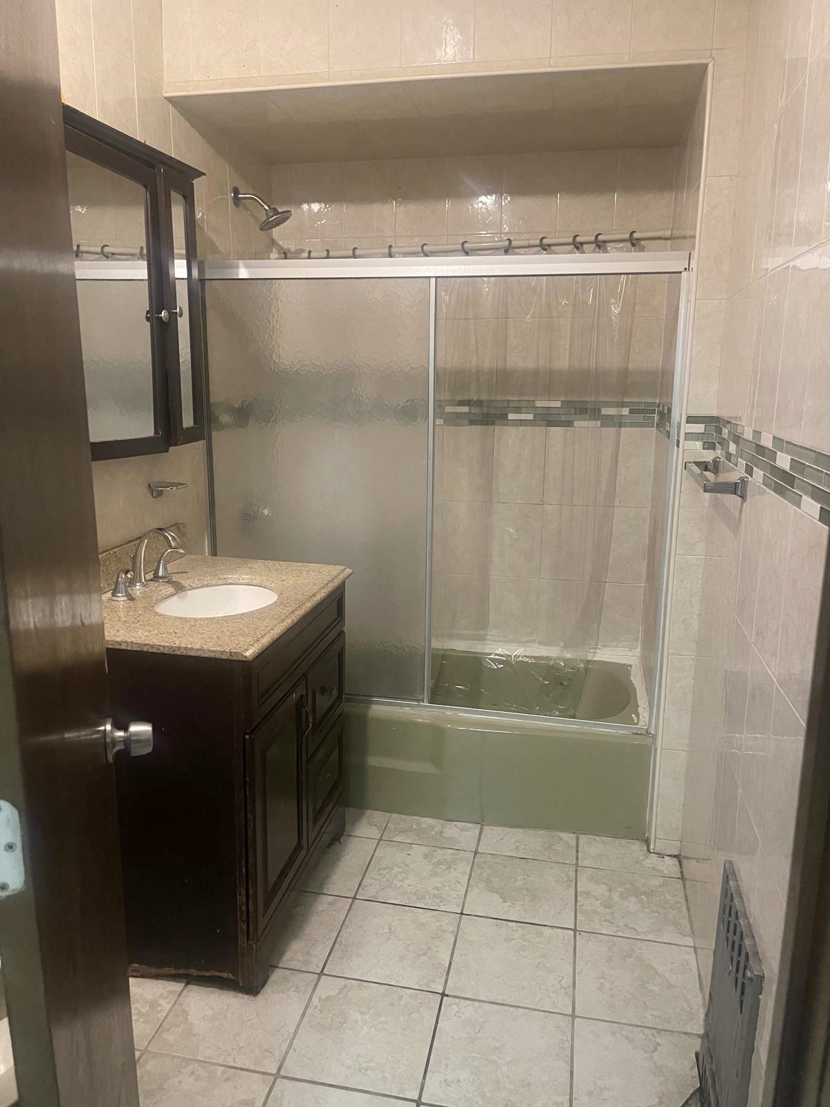 200 Hutton Street, Unit 1 Jersey City, NJ 07307 - Photo 2 of 5 a bathroom with a sink a mirror and a bathtub