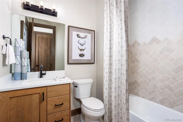a bathroom with a sink a toilet and shower curtain