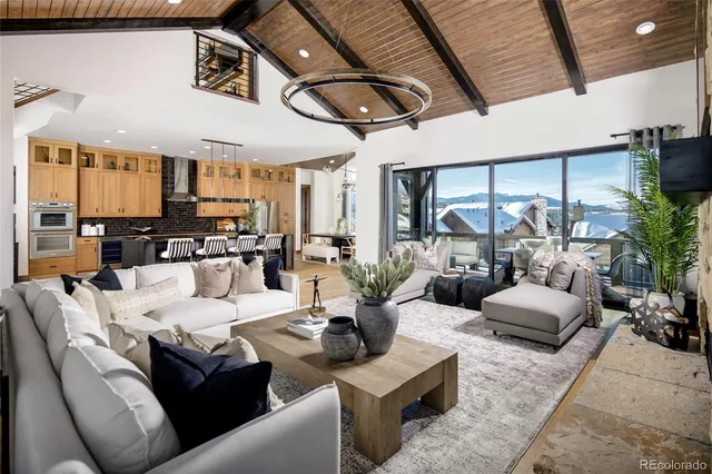 a living room with furniture kitchen view and large windows