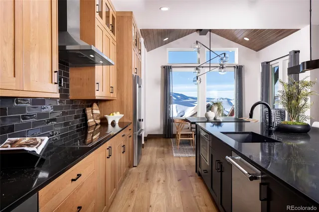 a kitchen with granite countertop a sink stove and cabinets