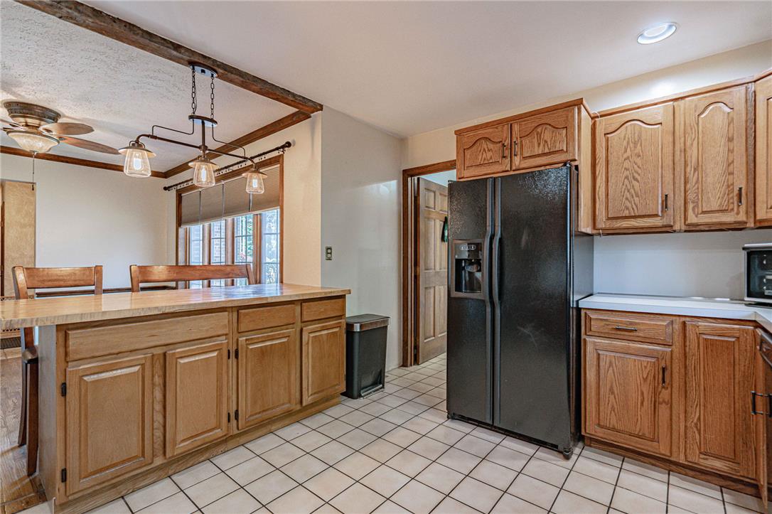 652 Old State Road Oley, PA 19547 - Photo 17 of 54 A well-equipped kitchen features solid wood cabinetry and tile flooring, offering a functional cooking space.