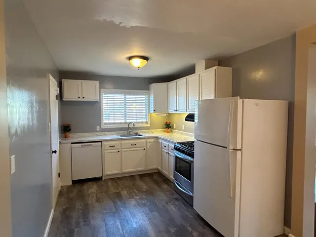 a kitchen with sink cabinets and white appliances