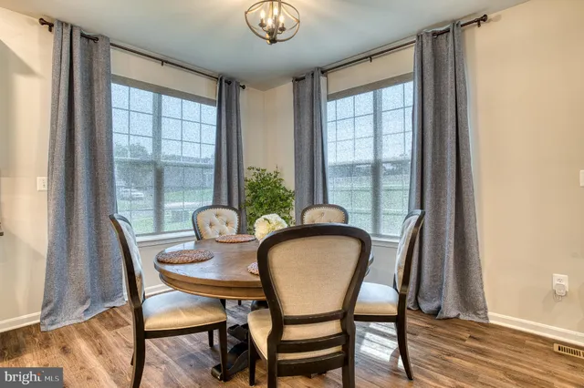 a bedroom with a bed dresser and a large window