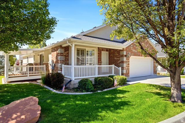 1089 West 2325th Street North Layton, UT 84041 - Photo 2 of 40 Brick facade residence with an attached garage, featuring a covered front porch with white railings