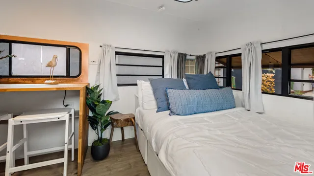 a bedroom with a bed and dresser with chair