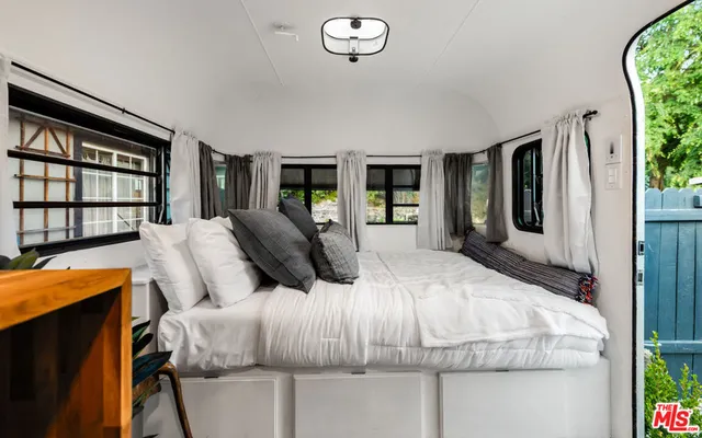 a bedroom with a large bed and a flat tv screen