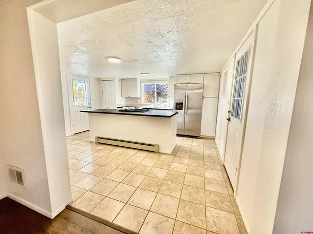 a kitchen with granite countertop a stove a sink and a refrigerator