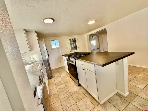 a kitchen with a sink a stove top oven and cabinetry