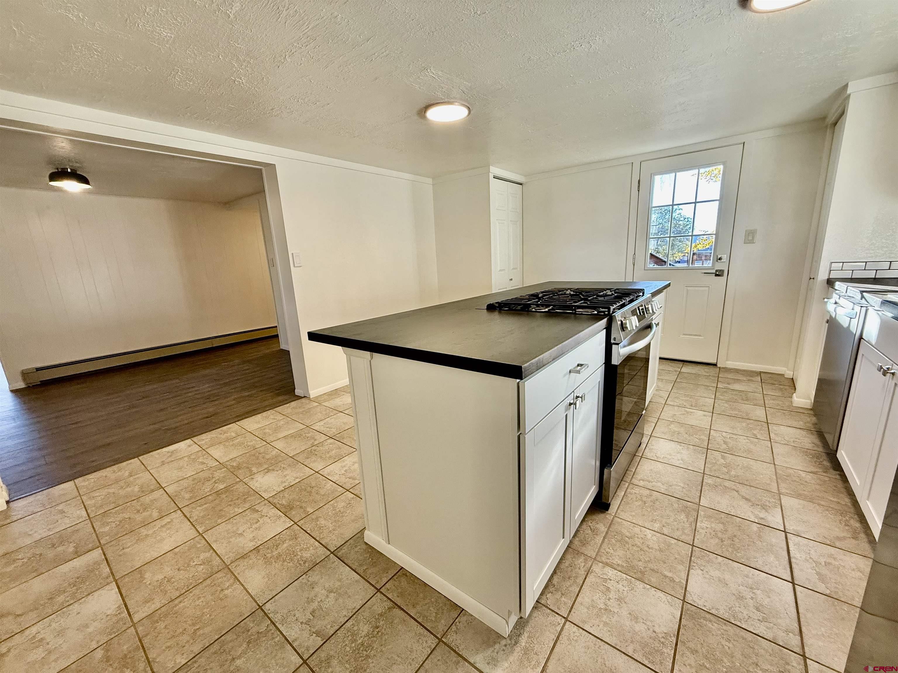 460 Fox Street Nucla, CO 81424 - Photo 17 of 33 a kitchen with granite countertop a stove a sink and a refrigerator