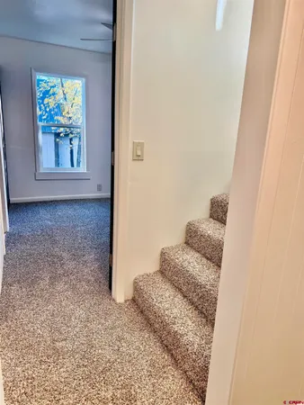a view of a hallway with wooden floor and front door