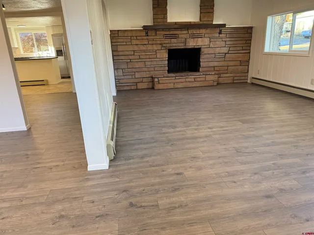 a view of empty room with wooden floor and fireplace