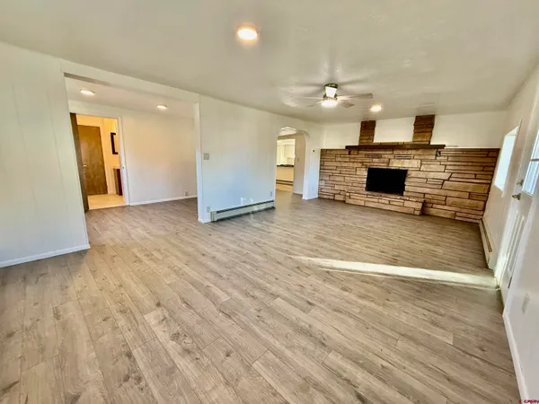 a view of empty room with wooden floor and fireplace
