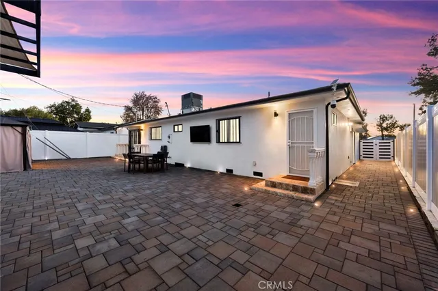 a backyard of a house with table and chairs