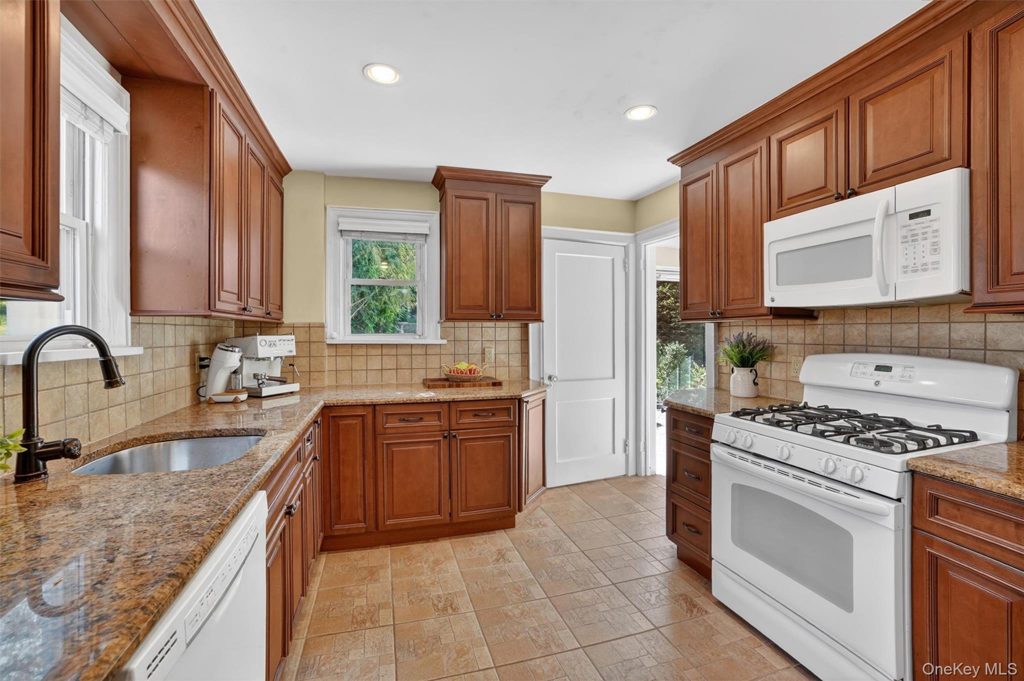 404 Bronxville Road Bronxville, NY 10708 - Photo 22 of 43 a kitchen with stainless steel appliances granite countertop a stove a sink dishwasher and a refrigerator